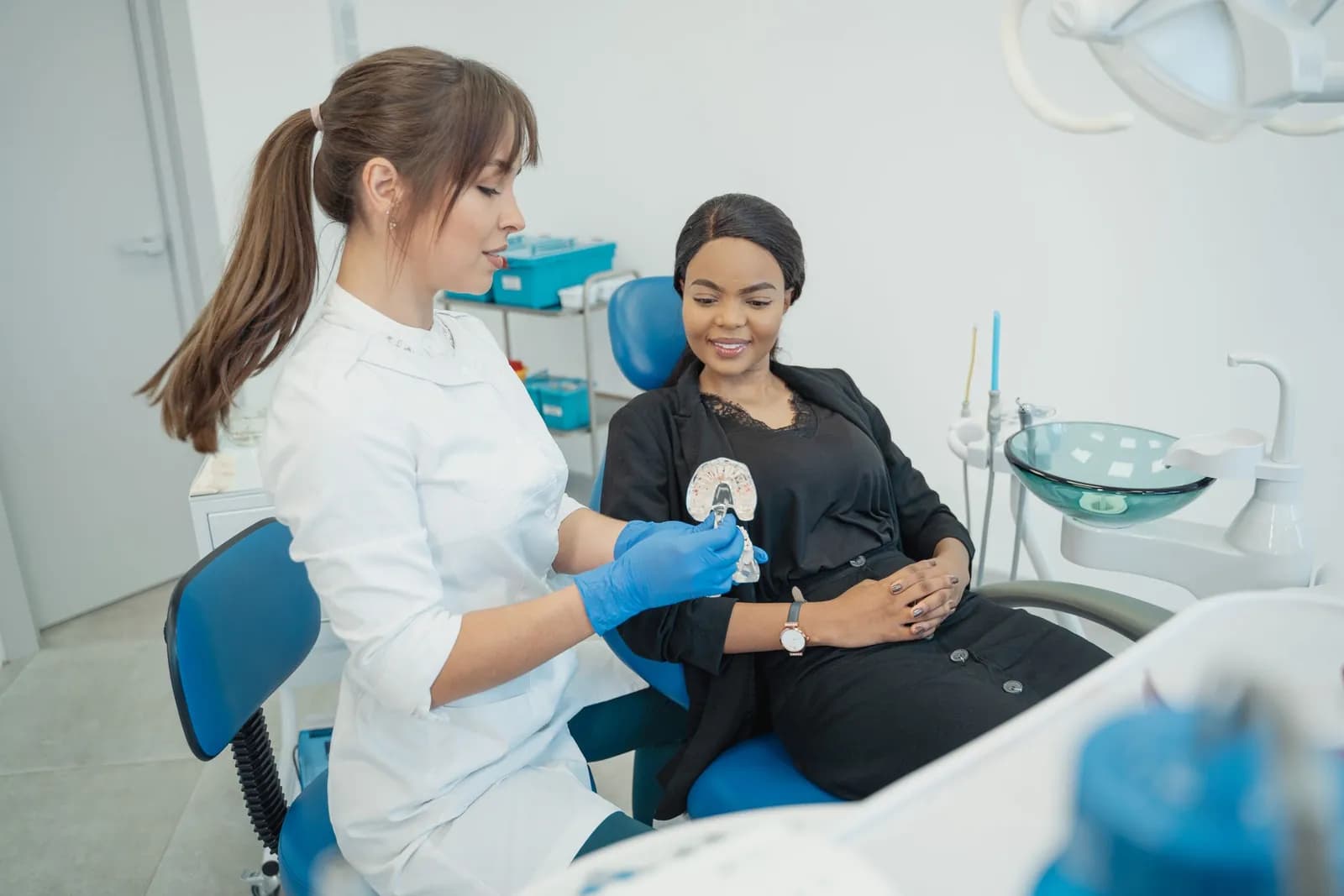 A dentist with a smiling patient in the dental chair